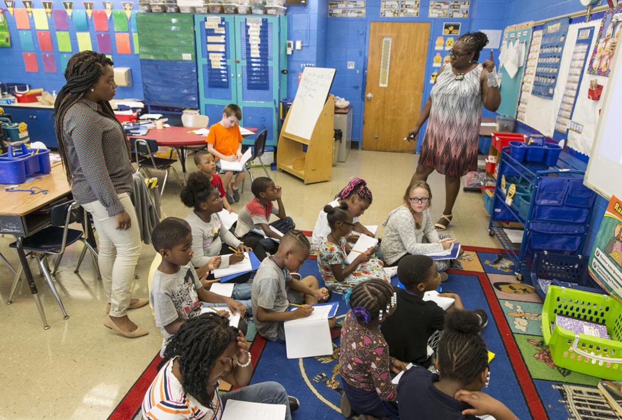 NaQue Walker (left) and 19-year veteran Sheila Mosby teach a math class at Cool Spring Elementary in Petersburg. The school district now has a program in which VCU students get master’s degrees while teaching in public schools under the supervision of mentors. (DANIEL SANGJIB MIN/times-dispatch)