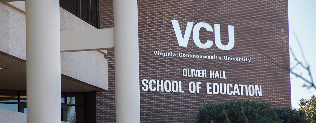 The front of Oliver Hall with the old VCU logo and the name of the school.