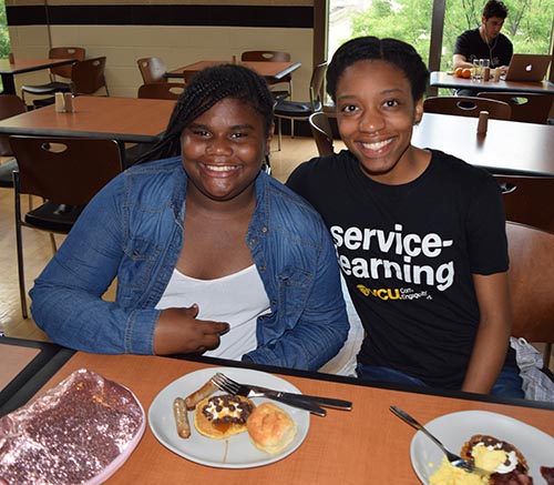 Two pen pals (from left: a fifth-grade student at Barack Obama Elementary School, and a VCU School of Education student) enjoy a snack together in the Shafer Court Dining Center.