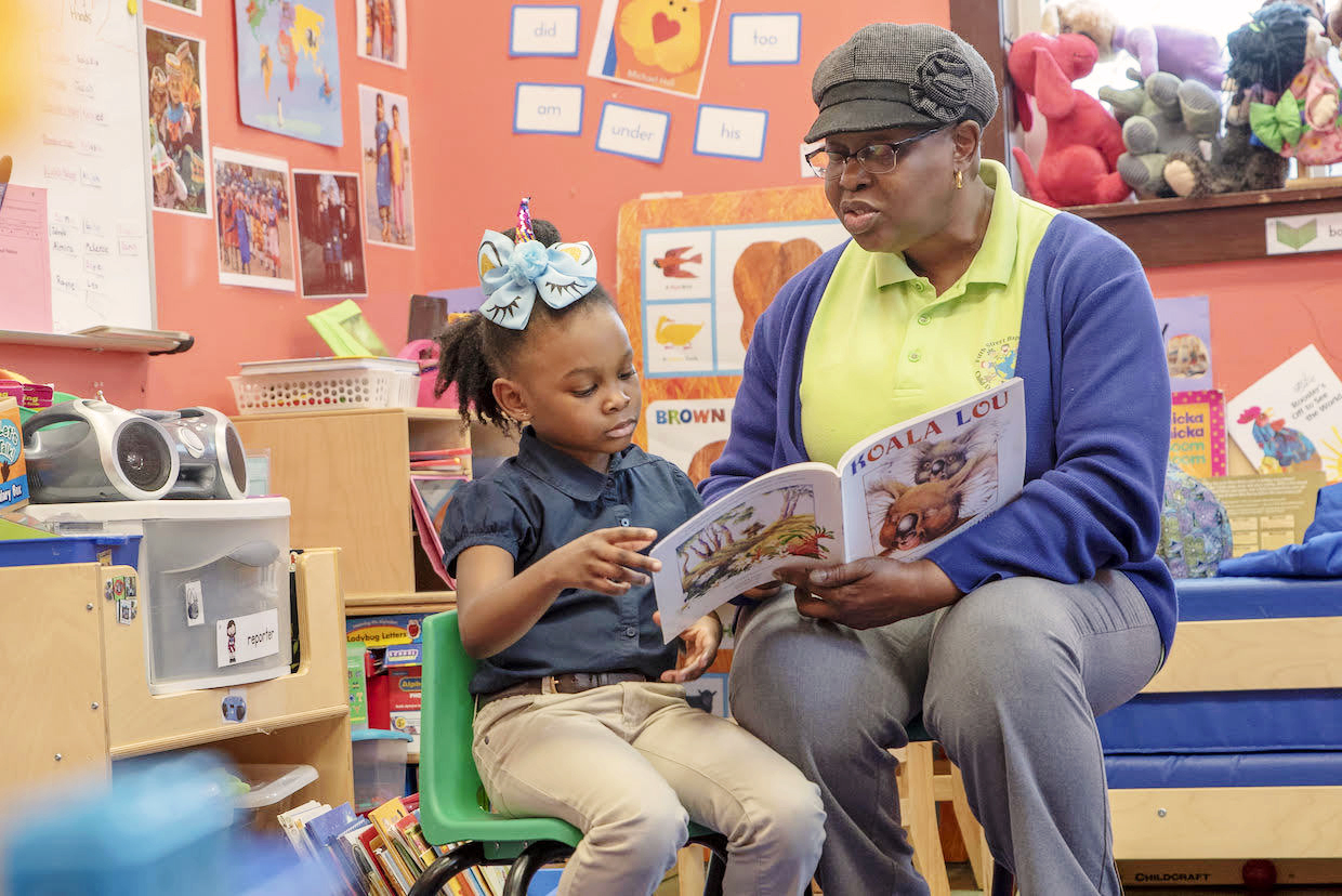 Valarie Wells-Bryant and her daughter Sophia sit in a room, reading a book together. (Photo by Jud Froelich)
