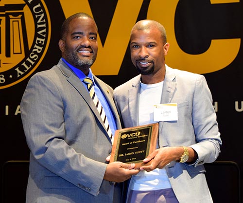 Dean Andrew Daire presents Dr. LaRon Scott with the Award of Excellence at the 2019 Awards Luncheon.